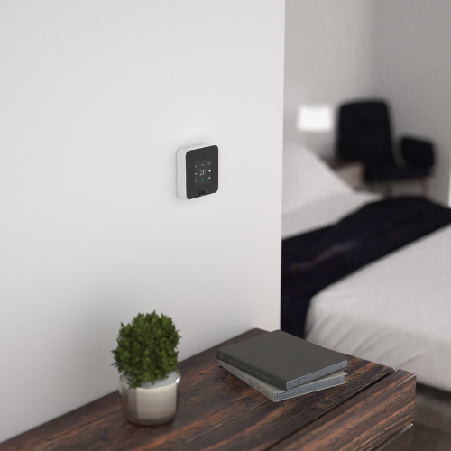 EOS Smart Thermostat mounted on the hotel room wall, displaying guest comfort settings and temperature control.